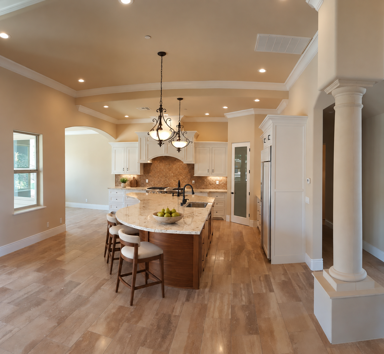 Open kitchen framed by columns and a tray ceiling