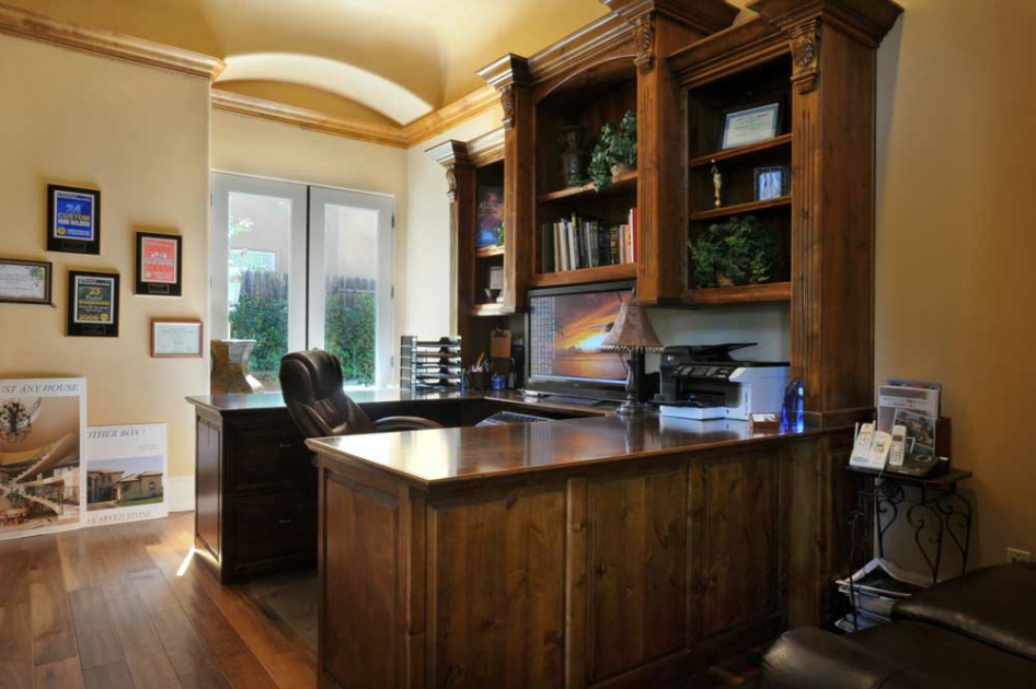 Home office with custom wood cabinetry and a garden-facing desk