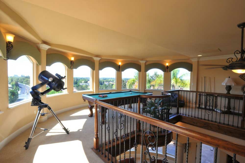 Billiard room beneath a row of arched windows