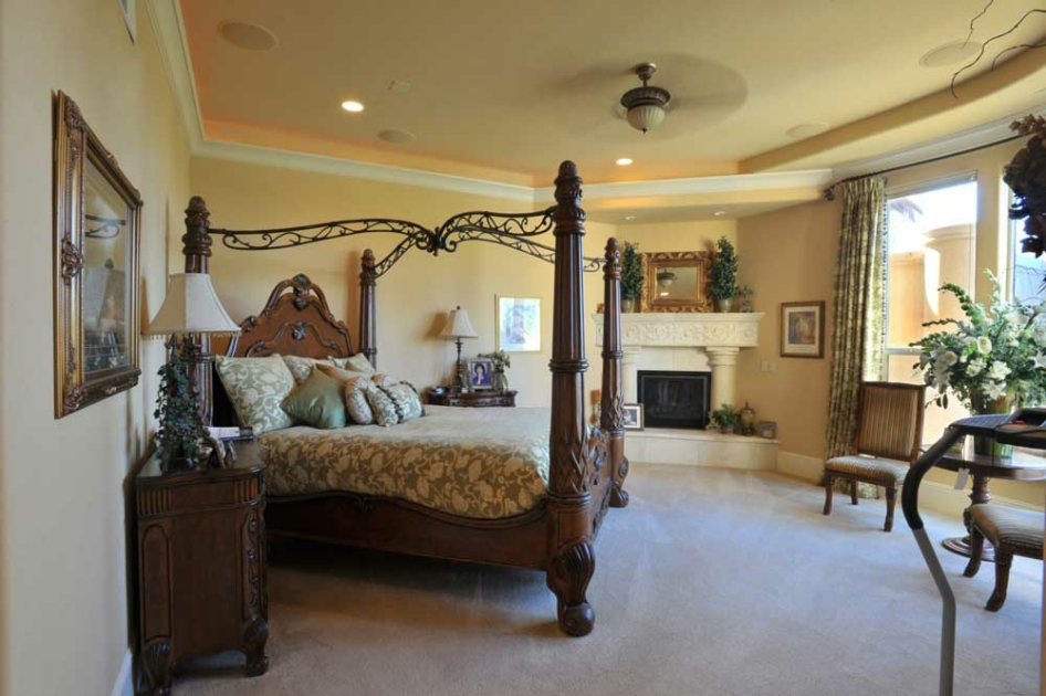 Primary suite with a carved four-poster bed and sitting area